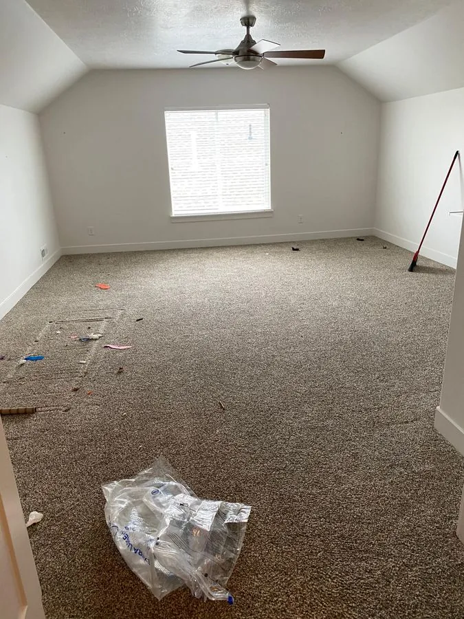 Before cleaning — messy bedroom with construction debris and trash scattered across carpet in Bluffdale Utah